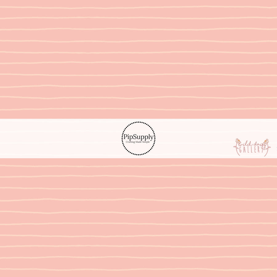 These stripe themed light pink fabric by the yard features small cream pinstripes on light peach.