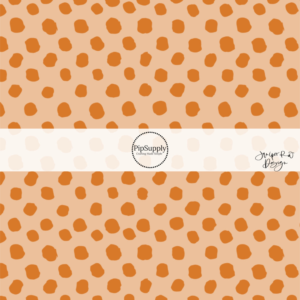 Scattered orange dots on beige hair bow strips