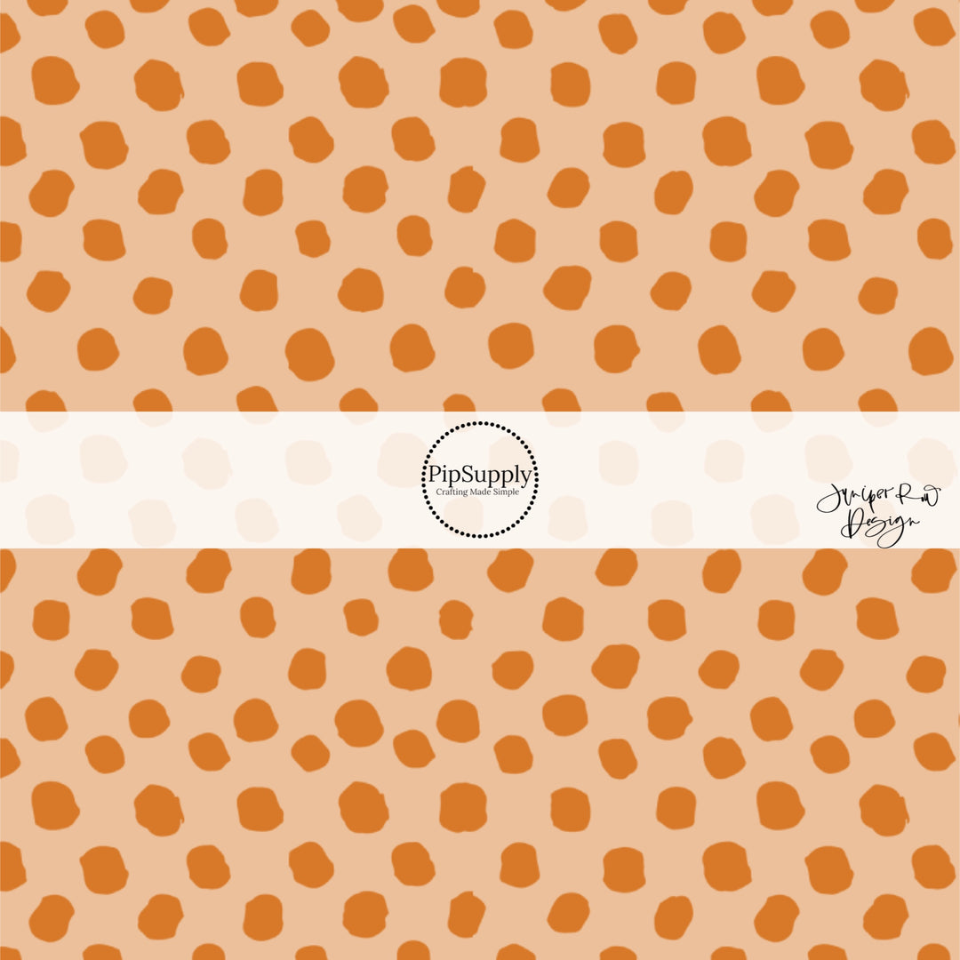 Scattered orange dots on beige hair bow strips