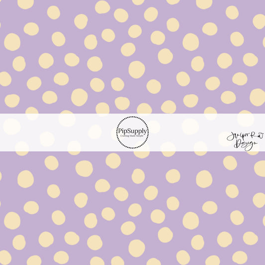 These dot themed pastel purple fabric by the yard features small white dots scattered on light purple.