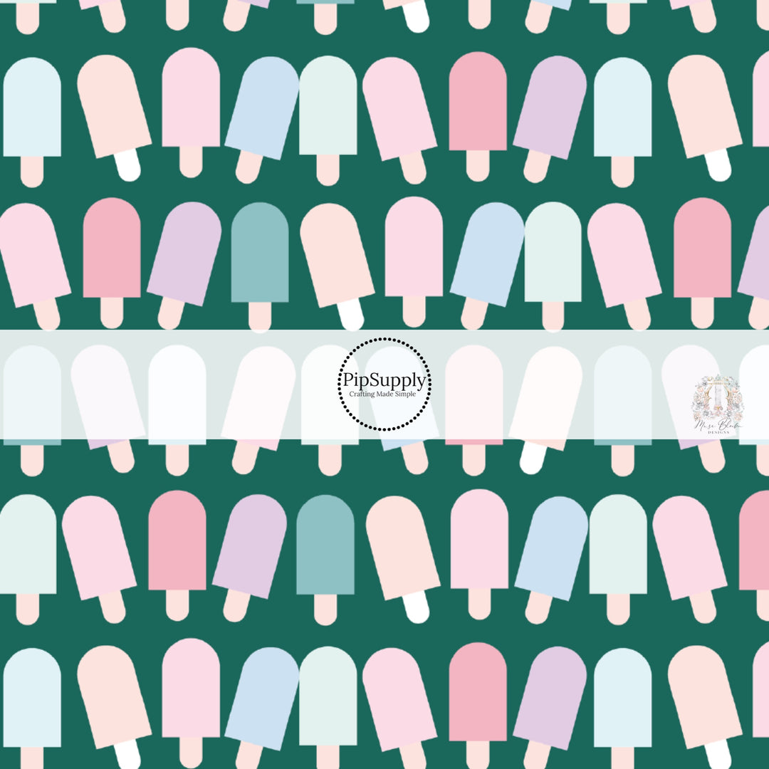 Light pink, light purple, light blue, aqua, light yellow popsicles on dark green fabric by the yard. 