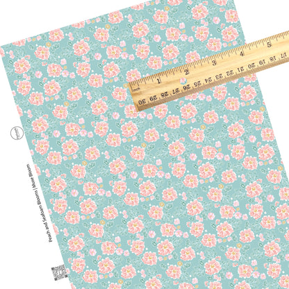  These floral themed light seafoam faux leather sheets contain the following design elements: light peach, cream, and teal flowers on seafoam. 