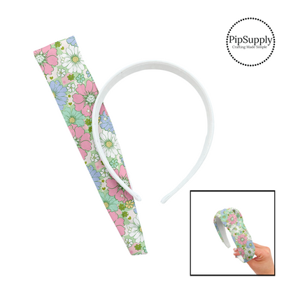 Light pink, green, blue, and white flowers of various sizes on a green and pink and cream checkered pattern DIY knotted headband kit. 