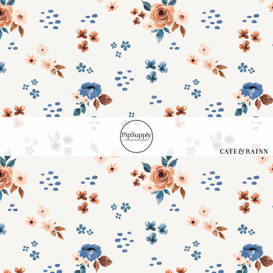 These floral themed cream fabric by the yard features cream, light pink, orange, and blue watercolor scattered floral flowers on cream. This fun floral summer themed fabric can be used for all your sewing and crafting needs! 