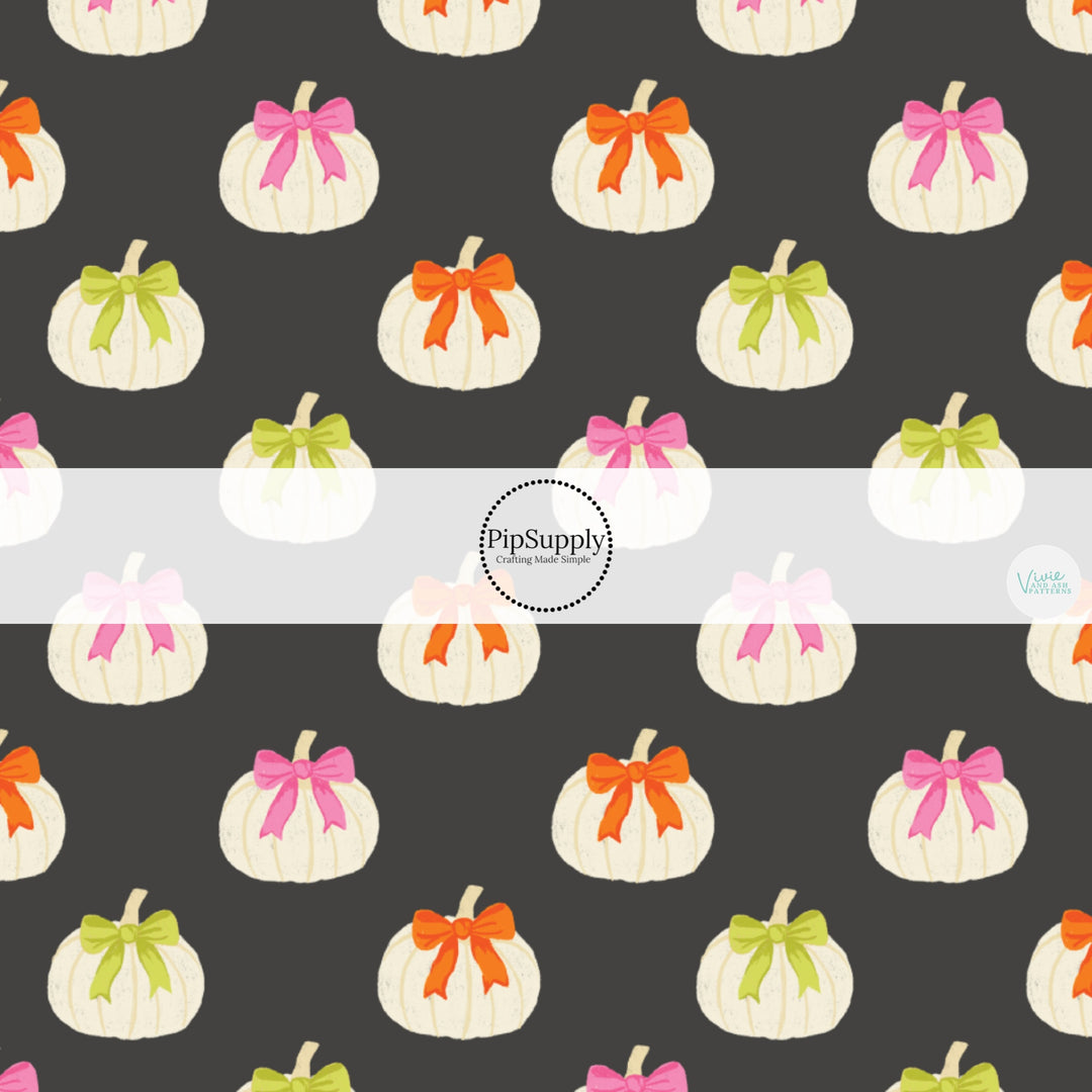 These Halloween themed pattern fabric by the yard features the following design elements: white pumpkins with bows on gray. This fun themed fabric can be used for all your sewing and crafting needs!