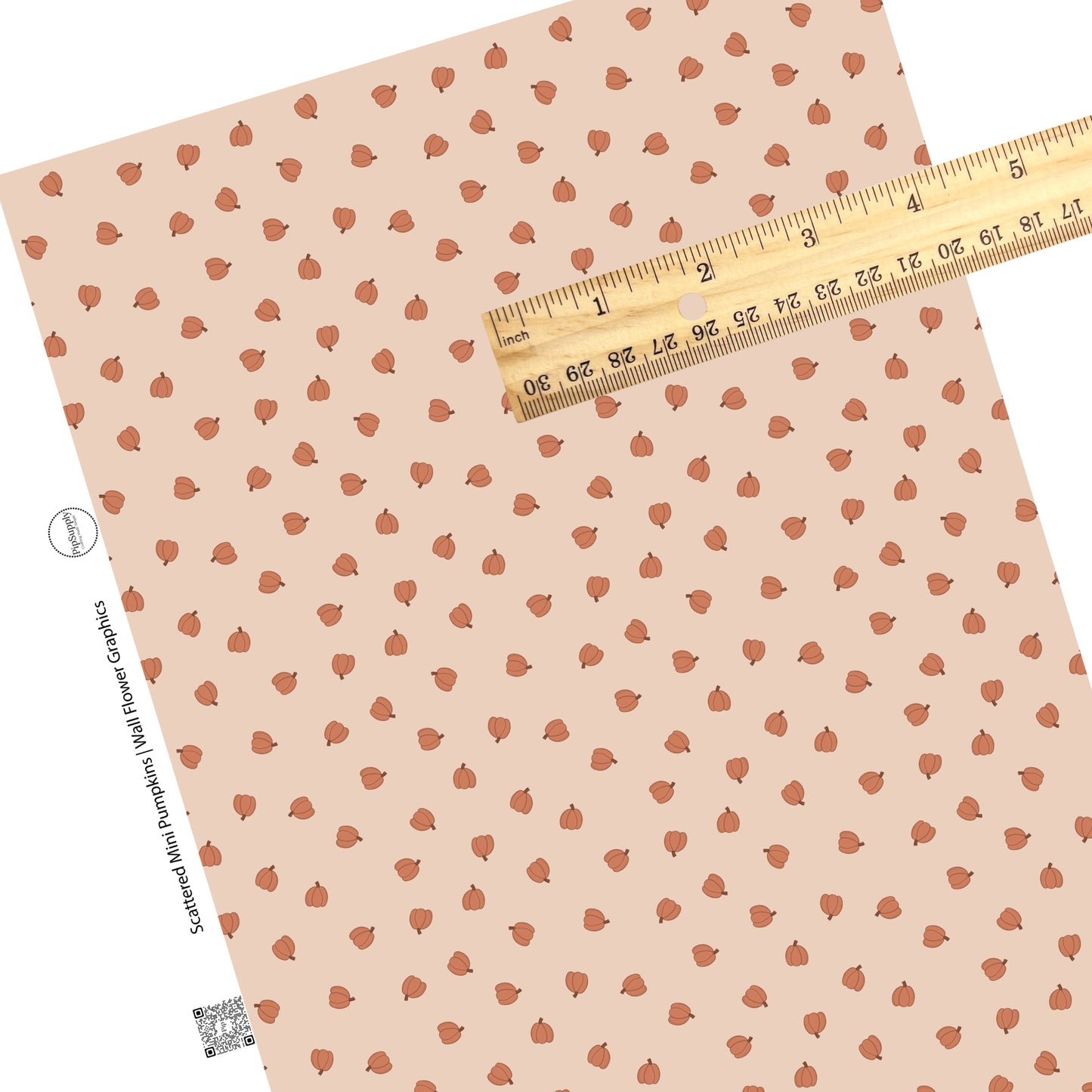 Scattered orange tiny pumpkins on peach faux leather sheets