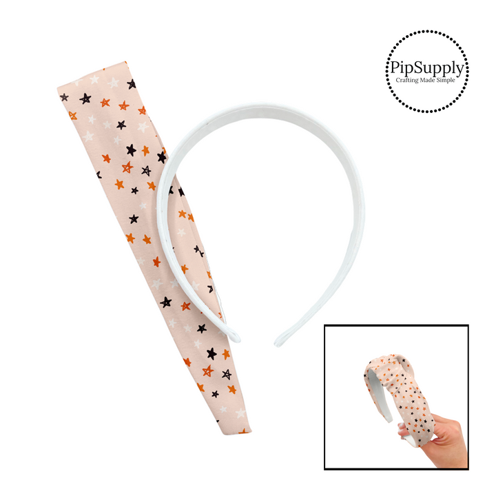 Drawn white, black, and orange stars on pastel orange knotted headband kit