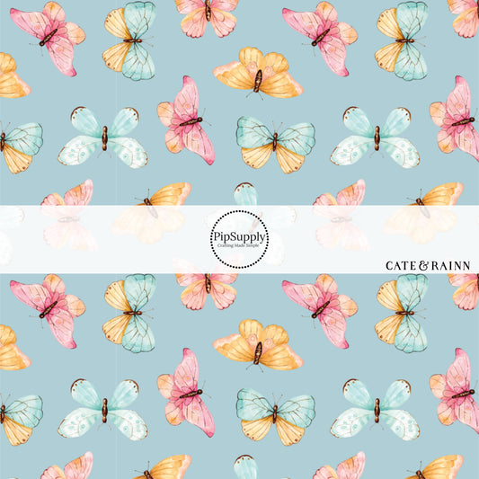 These butterfly themed blue fabric by the yard features light pink, orange, and blue butterflies on blue. This fun summer butterfly themed fabric can be used for all your sewing and crafting needs! 