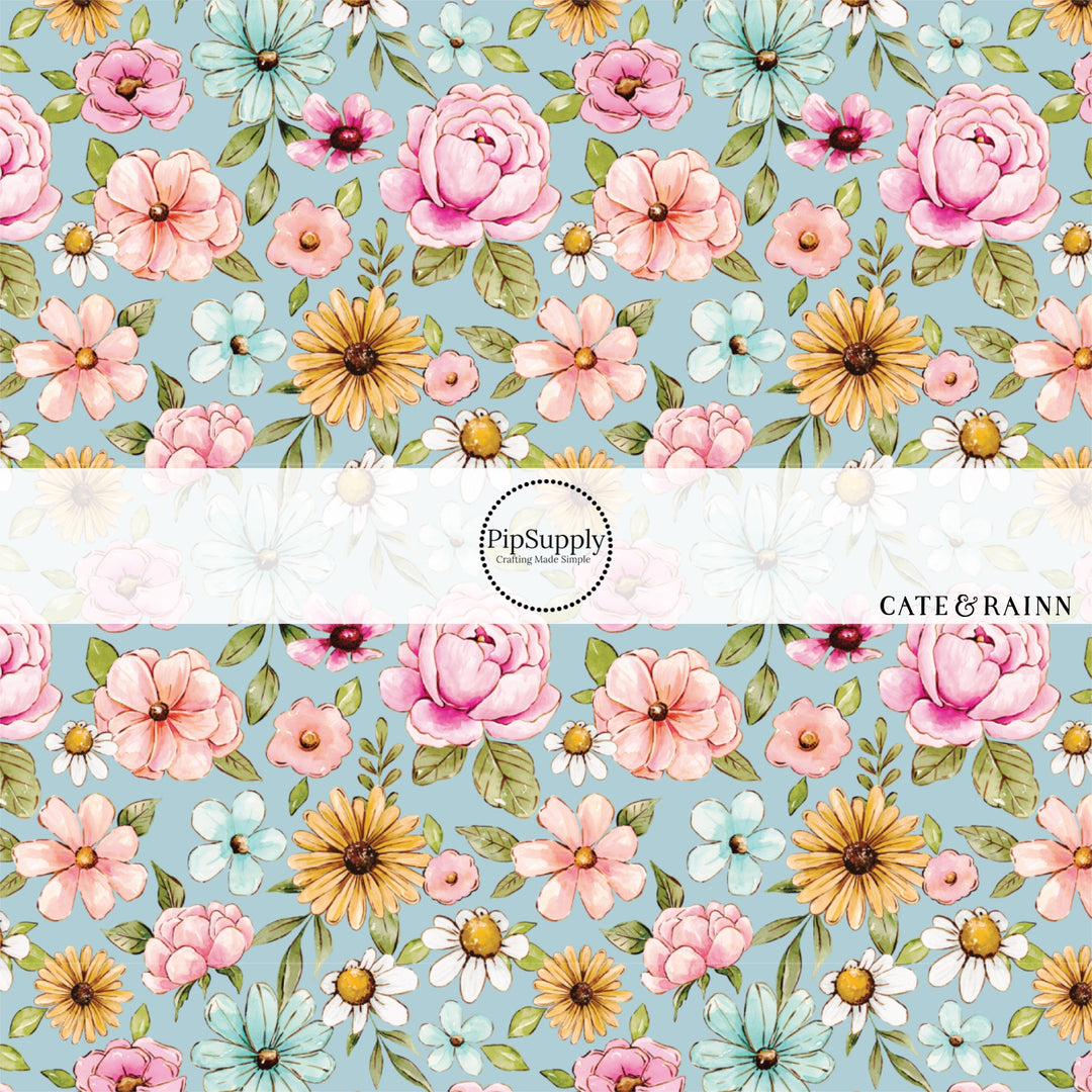 These floral themed blue fabric by the yard features light pink, orange, yellow, white and blue watercolor floral flowers on light blue. This fun floral summer themed fabric can be used for all your sewing and crafting needs! 