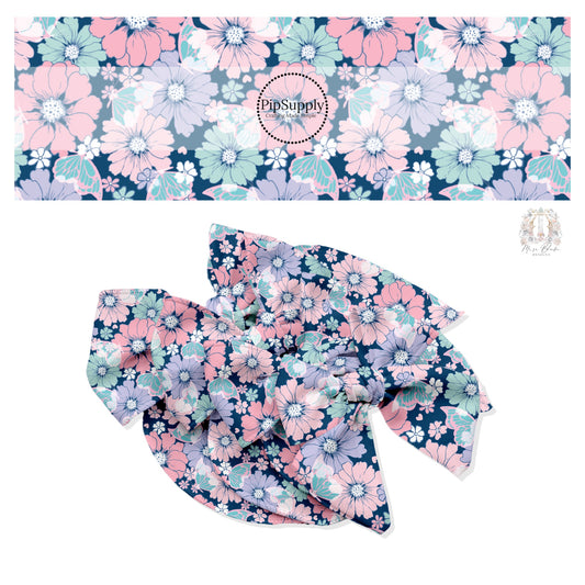 Light colored flowers in pink, aqua, purple, and white with aqua butterflies on dark navy hair bow strips. 