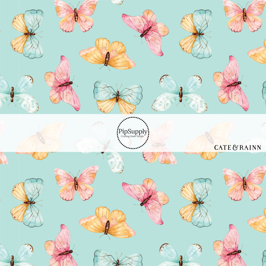 These butterfly themed blue fabric by the yard features light pink, orange, and blue butterflies on blue. This fun summer butterfly themed fabric can be used for all your sewing and crafting needs! 