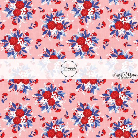 These red, white, and blue floral bouquets on light pink fabric by the yard features white, royal blue, and red beautiful flowers and leaves.