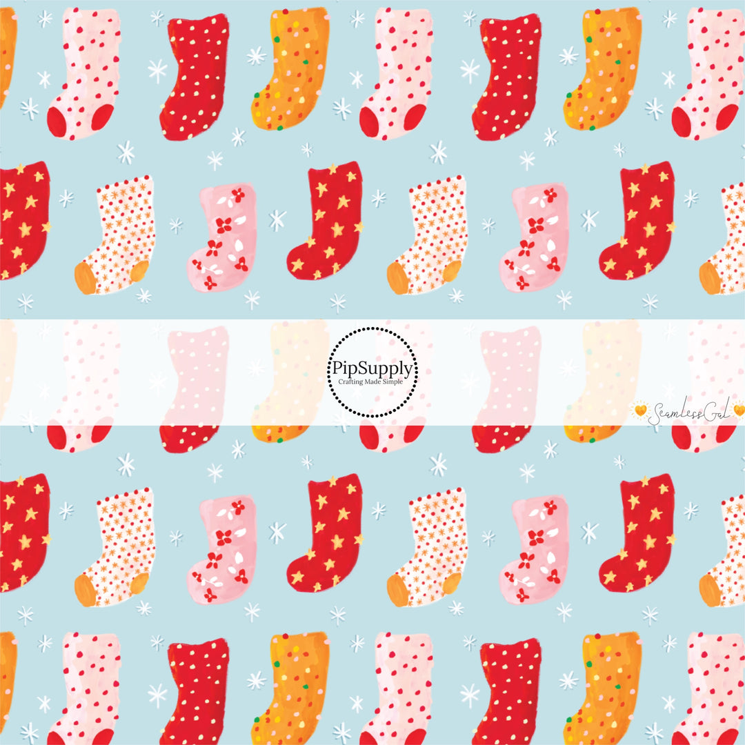 These Christmas themed pattern fabric by the yard features the following design elements: colorful Christmas stockings on blue. This fun themed fabric can be used for all your sewing and crafting needs!