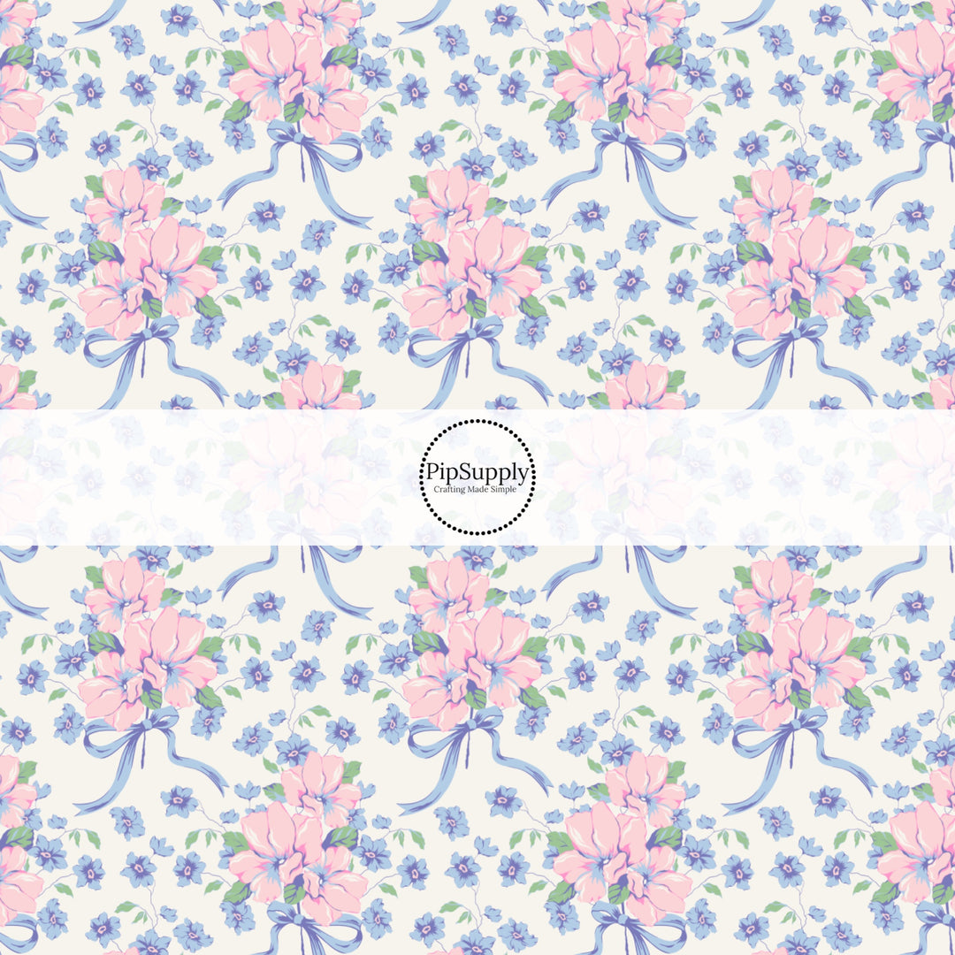 This spring floral themed fabric by the yard features blue and pink flowers with blue bows. This fun pattern fabric can be used for all your sewing and crafting needs!