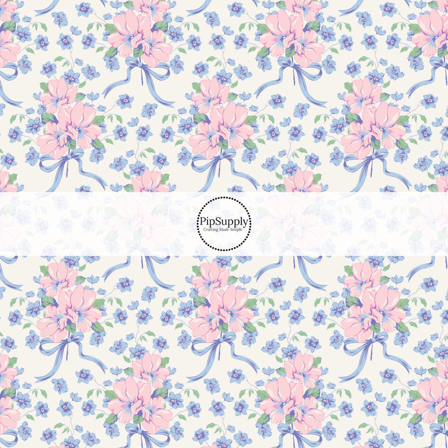 This spring floral themed fabric by the yard features blue and pink flowers with blue bows. This fun pattern fabric can be used for all your sewing and crafting needs!