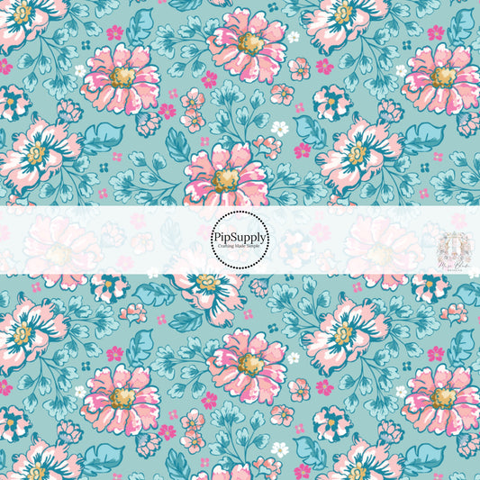 These floral themed blue fabric by the yard features hot pink, light pink, and aqua flowers on blue. This fun summer floral themed fabric can be used for all your sewing and crafting needs! 