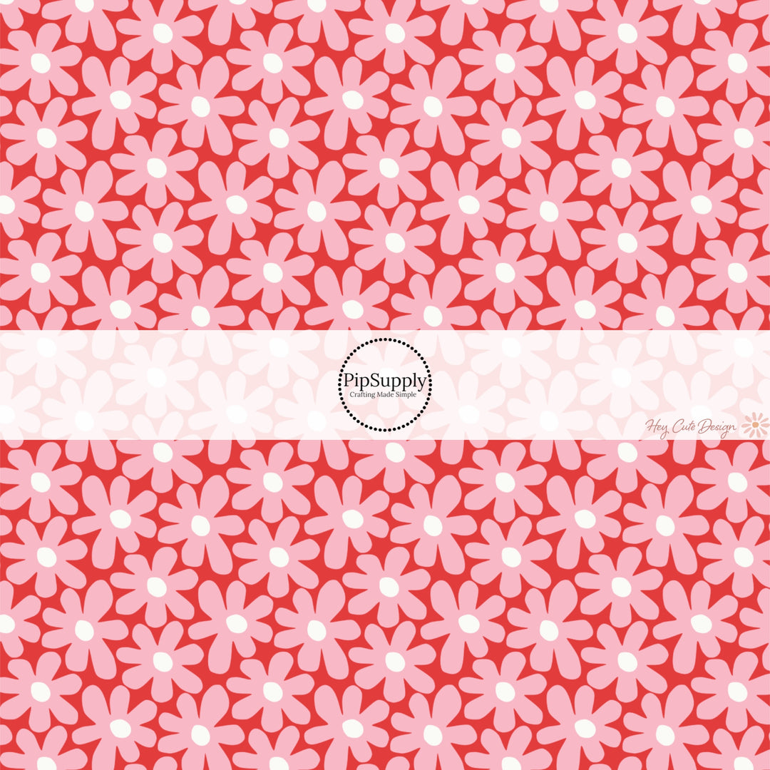 This holiday fabric by the yard features pink daisies on red. This festive pattern fabric can be used for all your sewing and crafting needs!