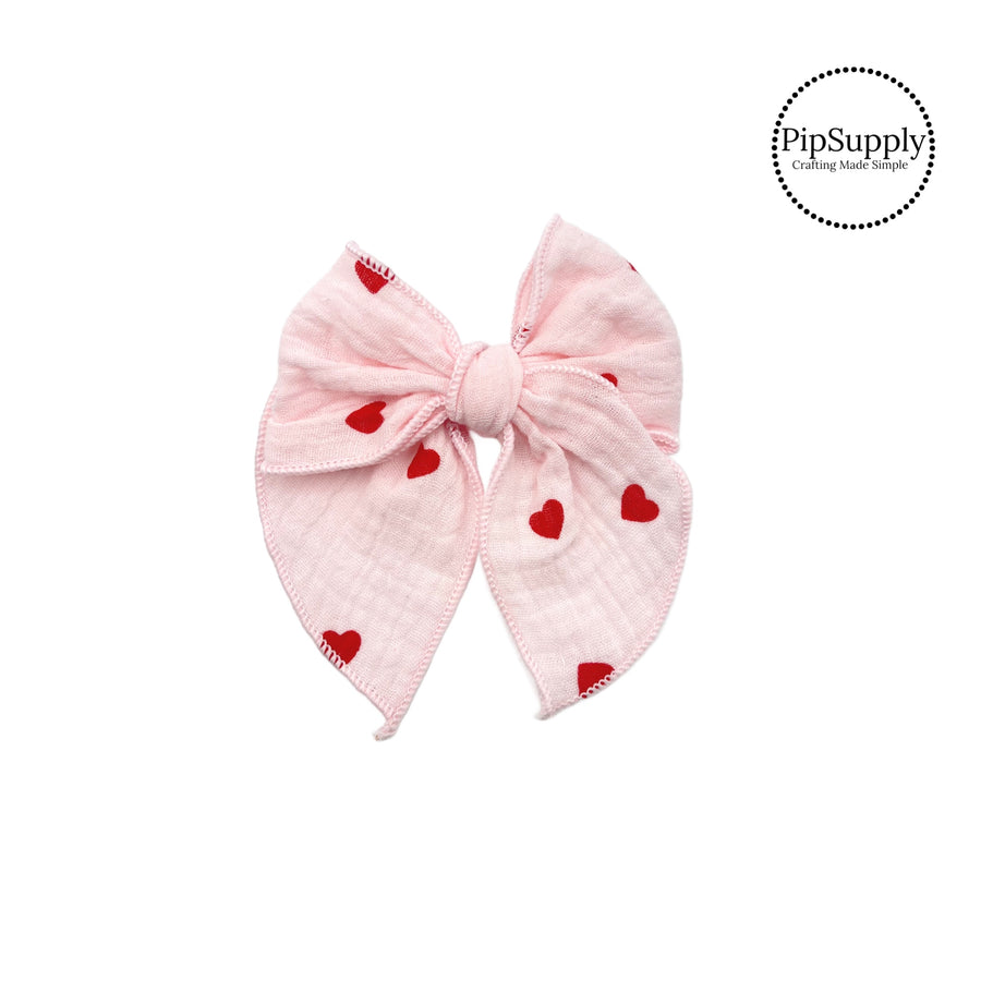 These pink muslin with red hearts pre-cut tied bows are ready to package and resell to your customers no sewing or measuring necessary! These hair bows come with a alligator clip already attached.