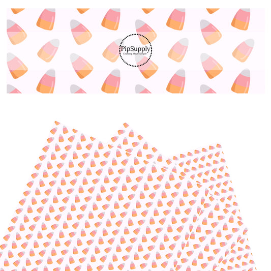 White, pink, and orange candy corn on white faux leather sheets