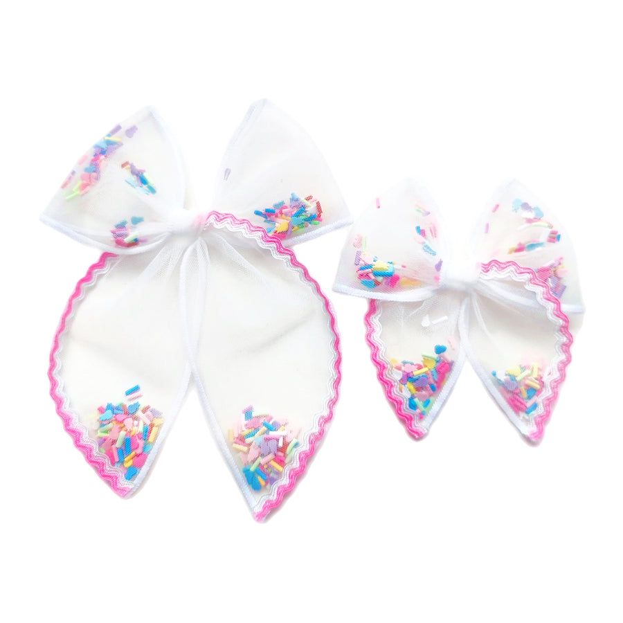 These spring berry pink ric rac white tulle pre-cut shaker tied bows are ready to package and resell to your customers no sewing or measuring necessary! These hair bows come with a alligator clip already attached and come filled with colorful Easter bunnies and sprinkles.