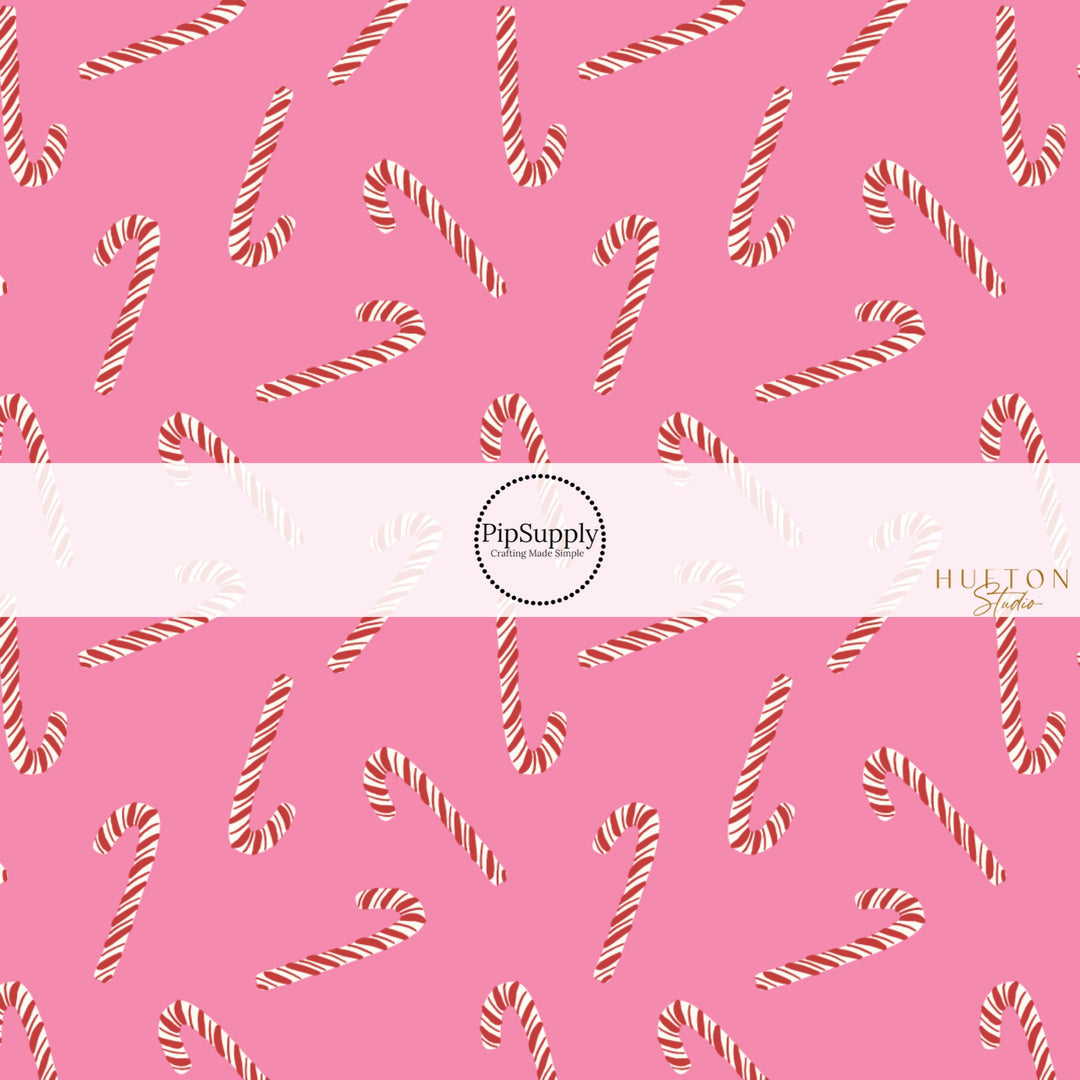 These Christmas themed pattern fabric by the yard features the following design elements: candy canes on pink. This fun themed fabric can be used for all your sewing and crafting needs!