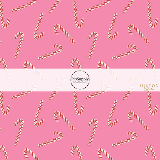 These Christmas themed pattern fabric by the yard features the following design elements: candy canes on pink. This fun themed fabric can be used for all your sewing and crafting needs!