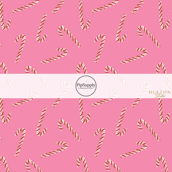 These Christmas themed pattern fabric by the yard features the following design elements: candy canes on pink. This fun themed fabric can be used for all your sewing and crafting needs!