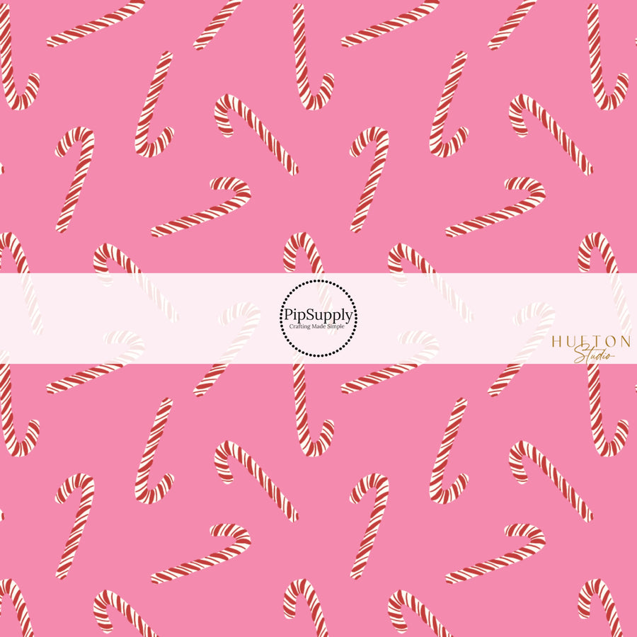 These Christmas themed pattern fabric by the yard features the following design elements: candy canes on pink. This fun themed fabric can be used for all your sewing and crafting needs!