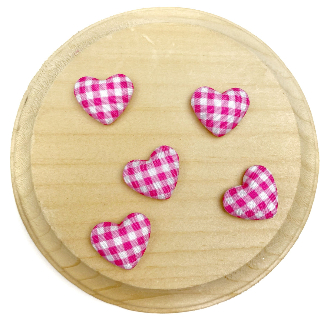 Heart-shaped flat back embellishment featuring a pink and white gingham plaid pattern with a softly padded, fabric-covered appearance. Finished with smooth edges and a charming, classic design, perfect for bows, hair accessories, scrapbooking, and craft projects.

Silver, flat backing
Sets of 10
Approx 1.9cm l x 1.58cm 