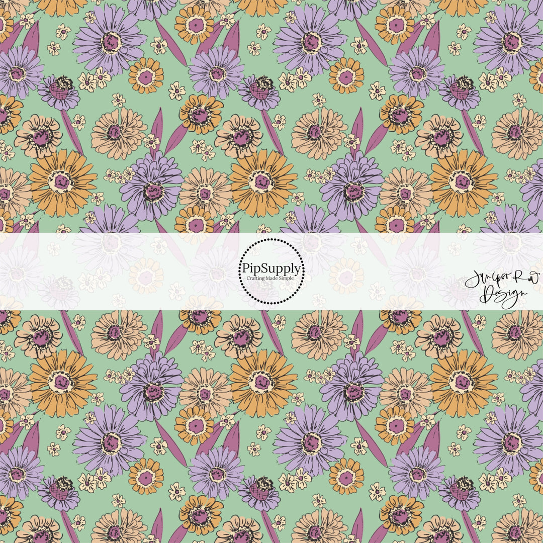 These floral themed light mint fabric by the yard features lavender, dark pink, cream, and orange flowers.