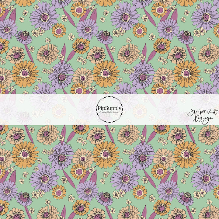 These floral themed light mint fabric by the yard features lavender, dark pink, cream, and orange flowers.