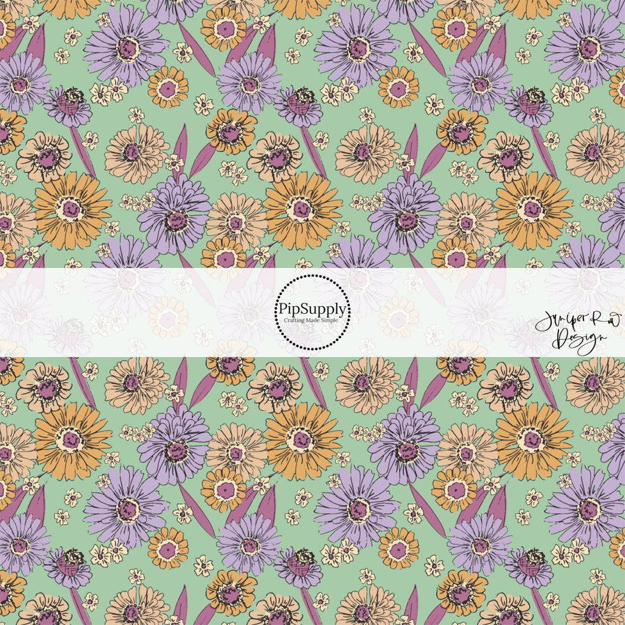 These floral themed light mint fabric by the yard features lavender, dark pink, cream, and orange flowers.