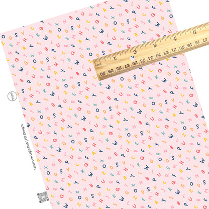 Scattered alphabet on light pink faux leather sheets
