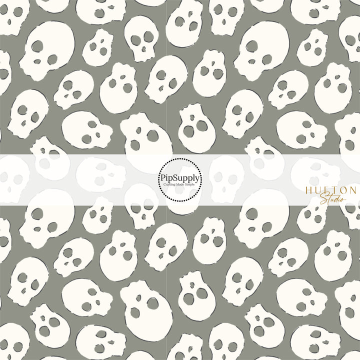 These Halloween themed pattern fabric by the yard features the following design elements: cream skulls on gray. This fun spooky themed fabric can be used for all your sewing and crafting needs!