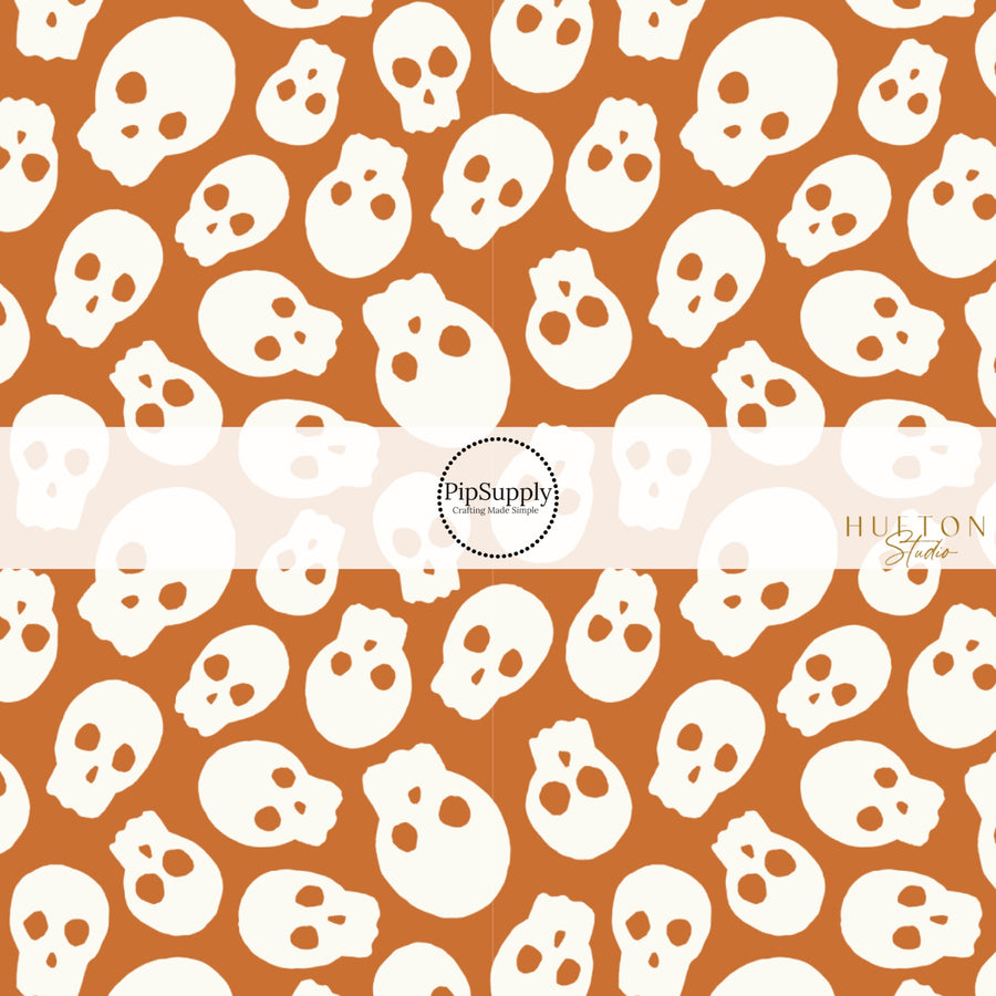 These Halloween themed pattern fabric by the yard features the following design elements: cream skulls on orange. This fun spooky themed fabric can be used for all your sewing and crafting needs!