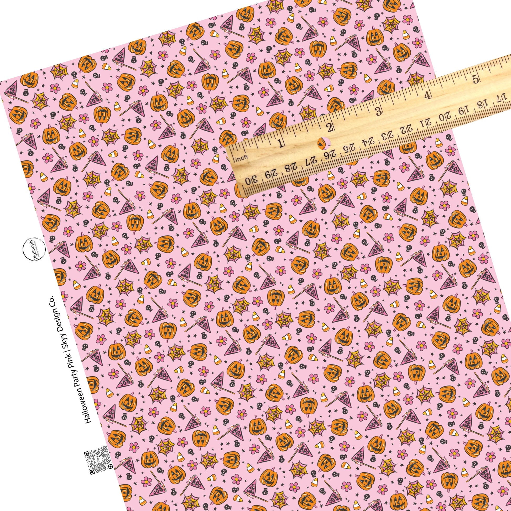 Scattered candy, pumpkins, flowers, and stars on pink faux leather sheets