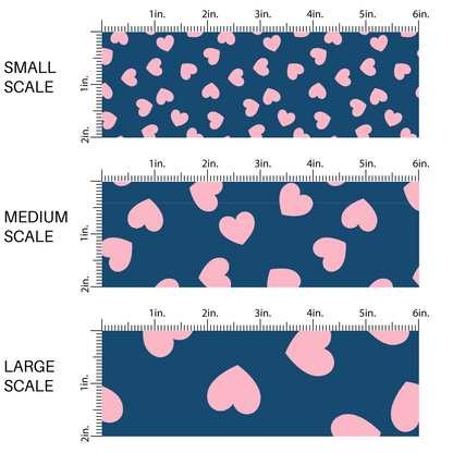 This image has three fabric scales of small, medium, and large scale for the light pink hearts in various directions on navy blue fabric by the yard.