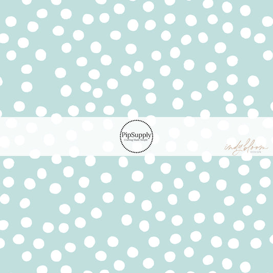 These small dots on a light teal fabric by the yard features small dots in white scattered on a teal blue background.