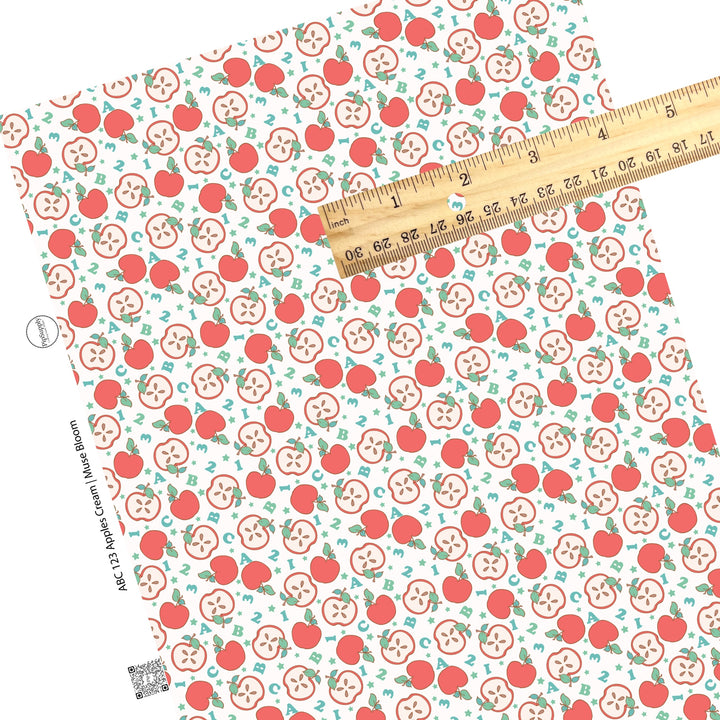 Scattered apples and halves with letters and numbers on cream faux leather sheets