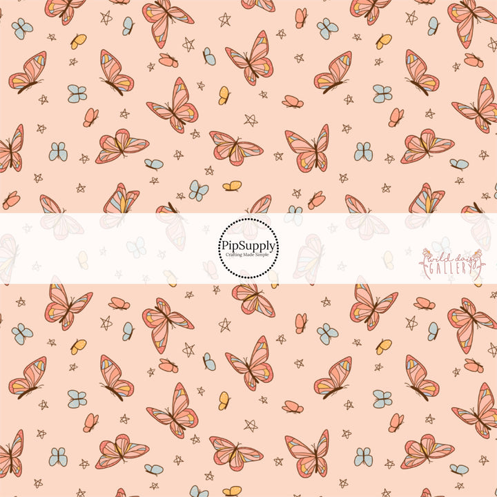 These butterfly themed light peachy cream fabric by the yard features small butterflies in light orange and light blue and larger colorful butterflies. 