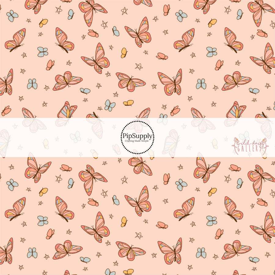 These butterfly themed light peachy cream fabric by the yard features small butterflies in light orange and light blue and larger colorful butterflies. 