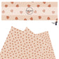 Tiny orange pumpkins scattered on peach faux leather sheets