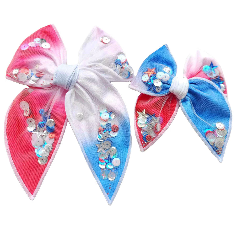 These patriotic watercolor shaker pre-cut tied bows are ready to package and resell to your customers no sewing or measuring necessary! These hair bows come with a clip already attached. The shaker bows come pre-filled with patriotic stars and sequin mix.