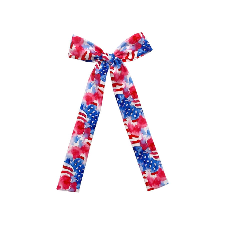 These patriotic watercolor waving flags long tail pre-cut tied bows are ready to package and resell to your customers no sewing or measuring necessary! These hair bows come with a clip already attached.