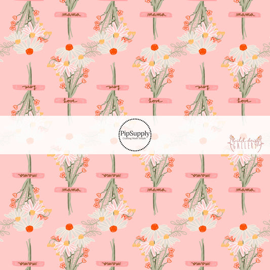 These wildflower daisy themed light pink fabric by the yard features white, cream, yellow, and orange daisy flower bouquets with pink ribbons. 