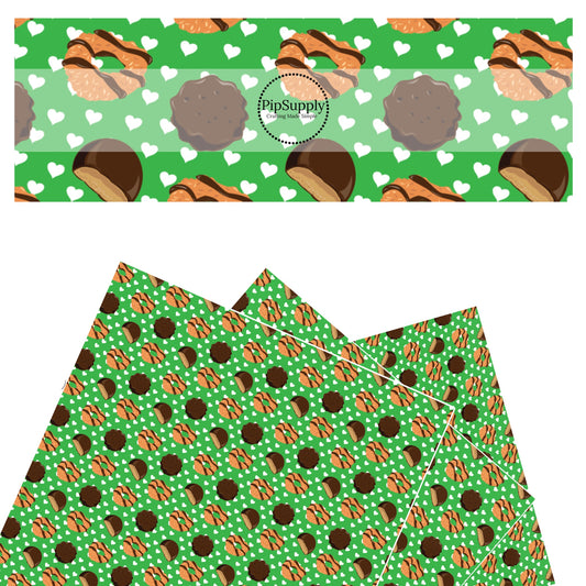 Chocolate cookies and white hearts scattered on green faux leather sheets