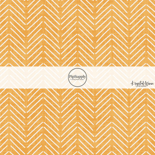 These mustard colored fabric by the yard features white arrows on light orange.