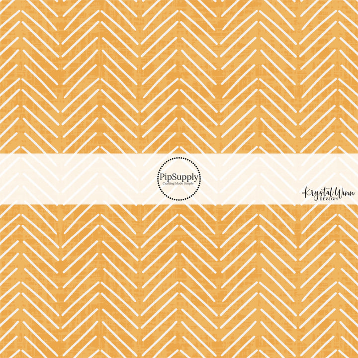 These mustard colored fabric by the yard features white arrows on light orange.