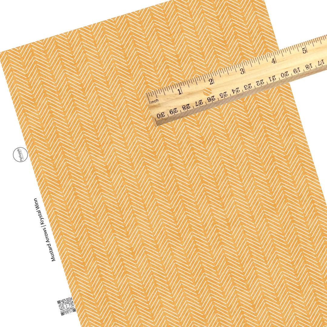 These mustard colored faux leather sheets contain the following design elements: white arrows on light orange.