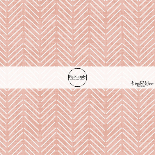 These blush fabric by the yard features white arrows on blush.